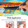 A hand holds a fine detail paint brush applying paint to a vibrant oil painting of a boat on water.