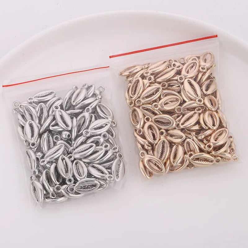 A collection of 50 plastic seashell charms, including cowrie and conch pendants, packaged for jewelry making.