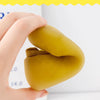 A hand holds a yellow soft sole sock shoe for babies and toddlers.