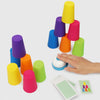 A hand holds a stack of colorful plastic cups for a stacking game, with several loose cups and cards nearby.