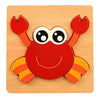 A red wooden crab puzzle set with orange claws and eyes on a light wood background.