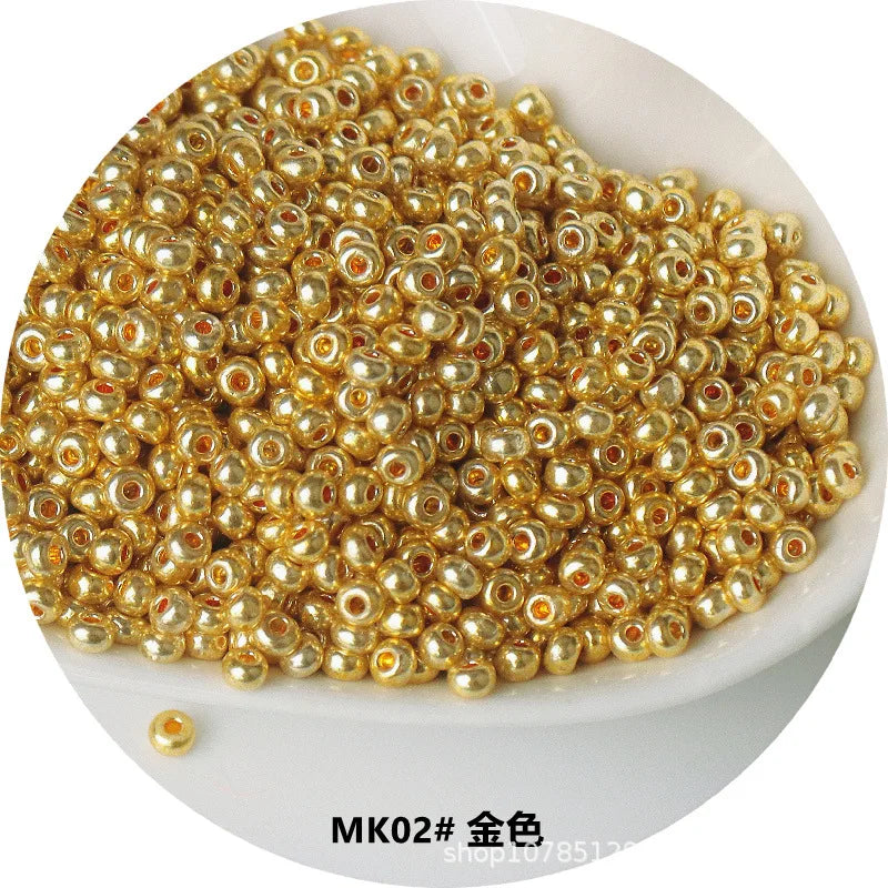 A pile of small, round, gold-colored electroplated metallic glass beads for jewelry and crafting.