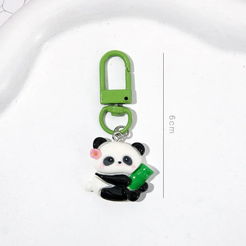 A small green padlock keychain featuring a cute panda charm with pink accents.