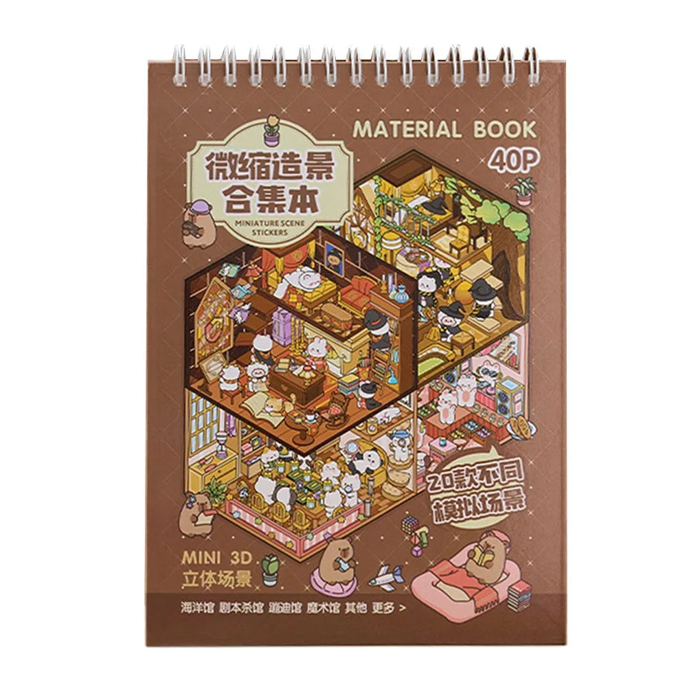 A brown notebook titled Material Book featuring illustrations of miniature scene stickers and a 3D cabin scene.