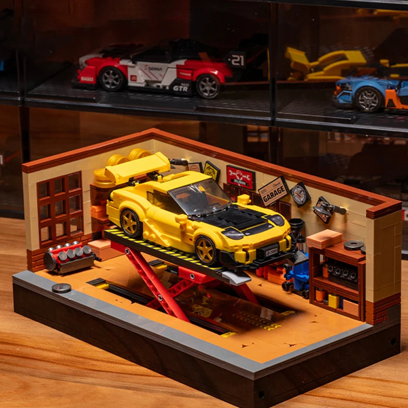 A detailed building block set depicting a retro car repair shop with yellow and red vehicles on a wooden platform.