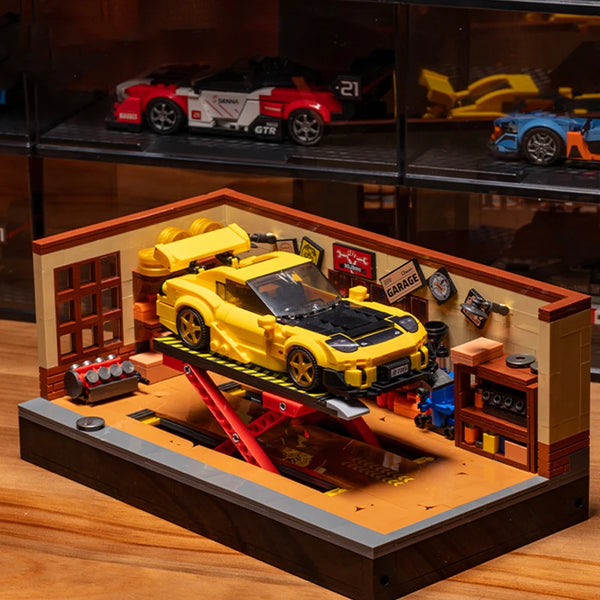 Detailreiches Bauklotz-Set einer Retro-Autowerkstatt mit gelben und roten Fahrzeugen auf einer Holzplattform.