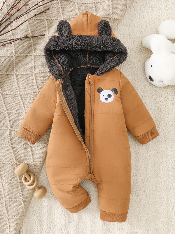 A brown fleece romper with a gray fur hood and a white bear face detail is shown on a cream textured background.