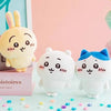 A collection of soft, cute Chiikawa Usagi plush toys and accessories displayed on a light blue surface.