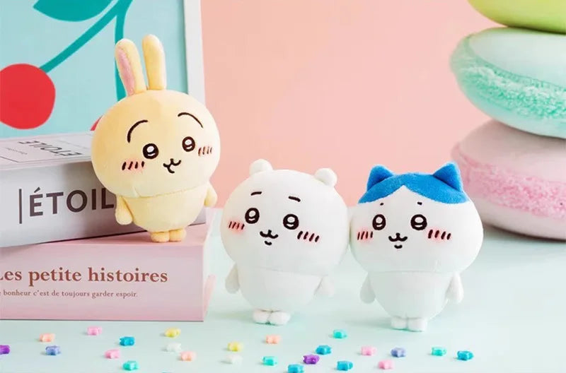 A collection of soft, cute Chiikawa Usagi plush toys and accessories displayed on a light blue surface.