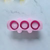 A pink flexible silicone mold with multiple circular depressions for DIY succulent plant pots.