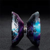 Gros plan d'un yo-yo en aluminium haute performance avec une finition iridescente violette et bleue.