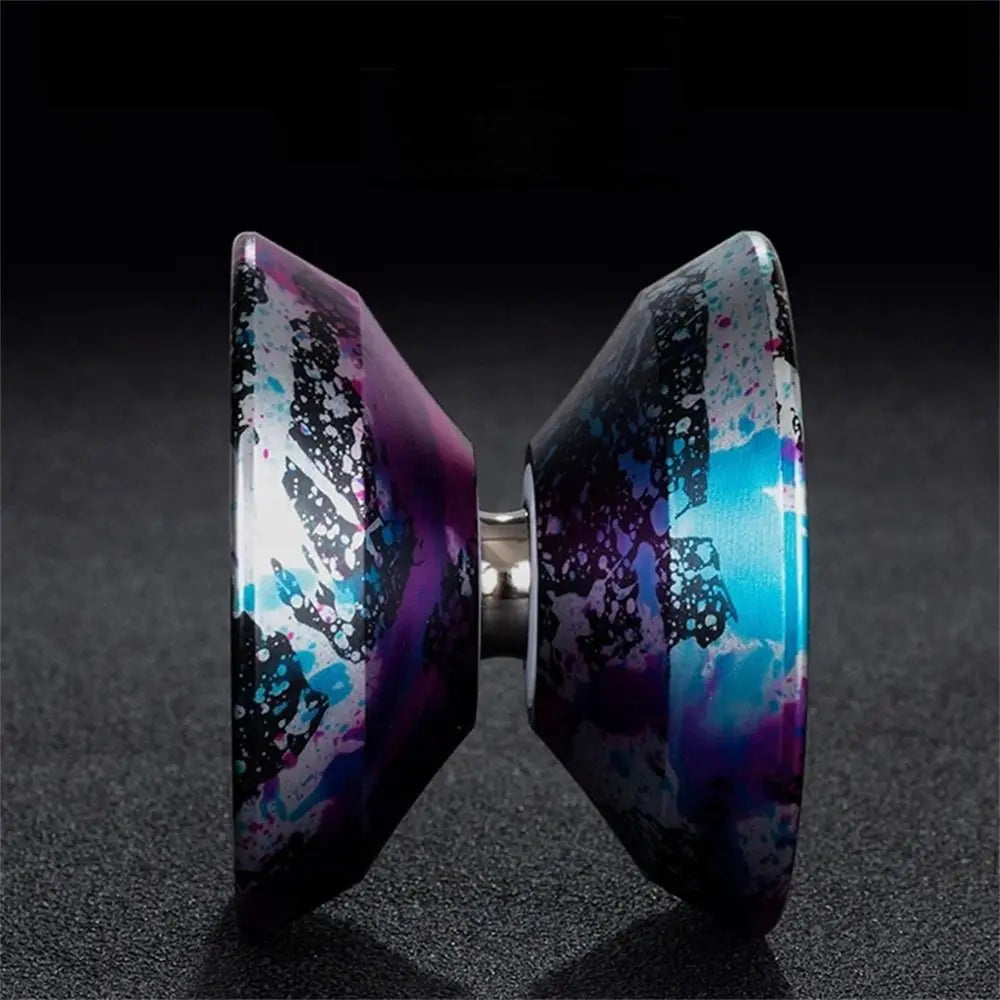 Gros plan d'un yo-yo en aluminium haute performance avec une finition iridescente violette et bleue.