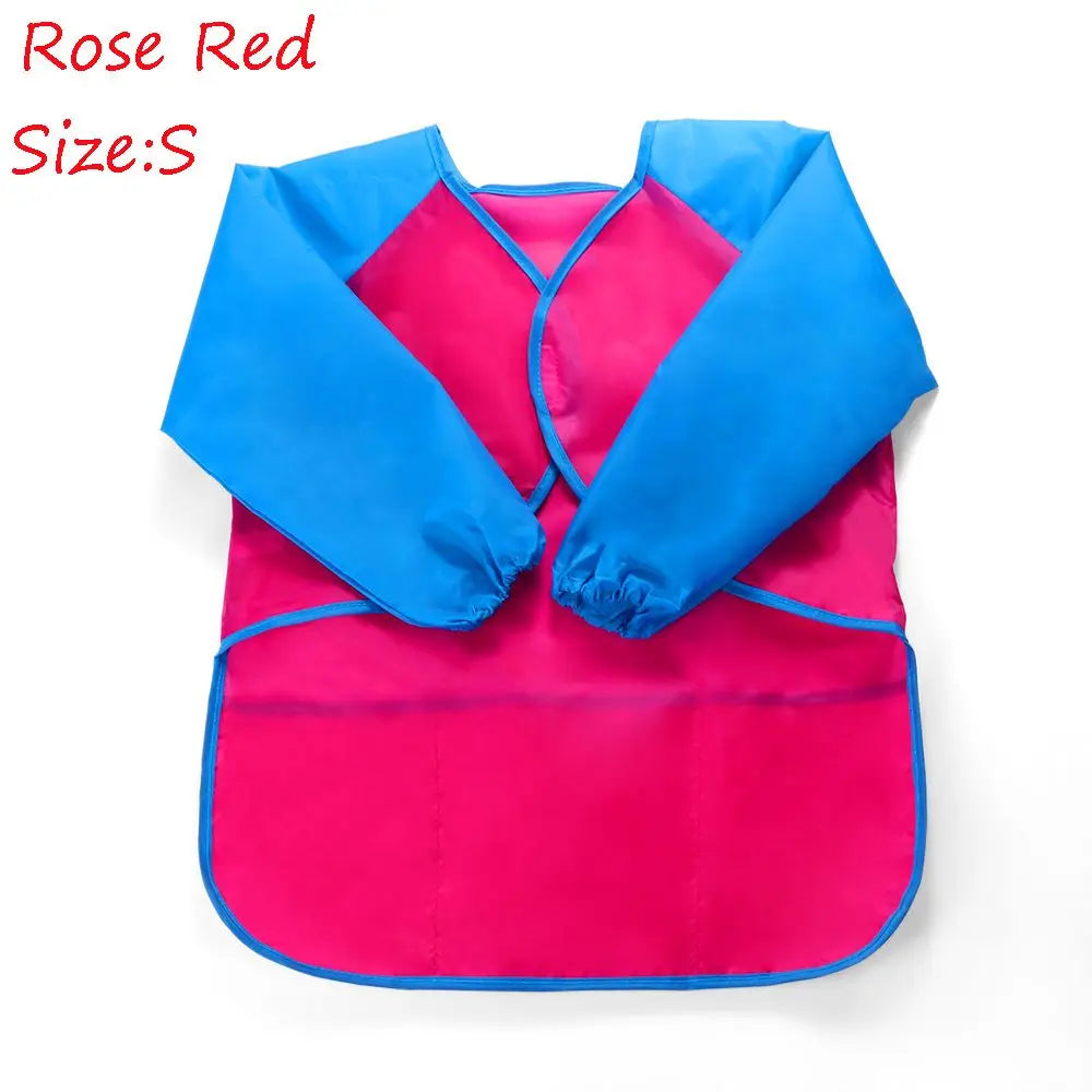 A bright pink and blue waterproof kids art and baking apron with long sleeves.