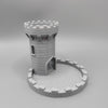 A gray medieval castle dice tower with a tray for tabletop games.