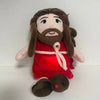 A plush doll resembling Jesus with long brown hair and a beard wearing a red garment.