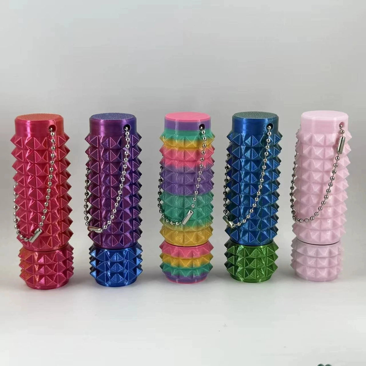 A set of colorful 3D printed spike roller fidget toys stacked in a row.