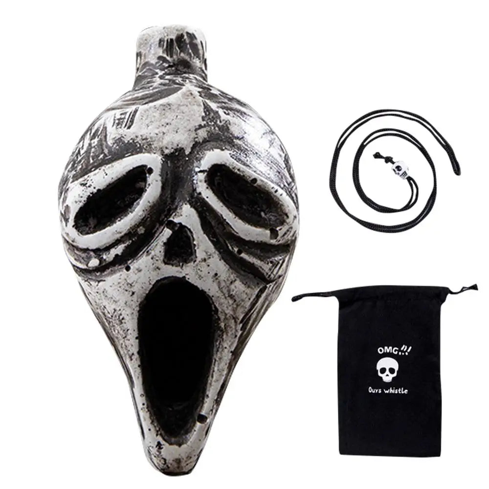 A ceramic Aztec skull whistle with a large open mouth and a coiled black cord.
