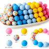 A collection of colorful silicone beads in various shades including pink, blue, and yellow for DIY crafts and jewelry.