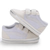 A pair of white canvas baby sneakers with light gray soles and white laces shown from the side.
