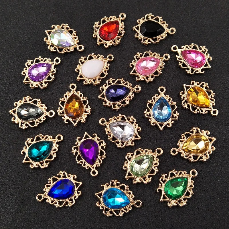 A collection of gold-plated water droplet charms featuring various colored crystal rhinestones and flower shapes.