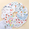 A collection of soft waterproof baby bibs in various patterns and colors laid out on a light background.