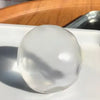 A clear, smooth, spherical fidget ball resting on a white surface.