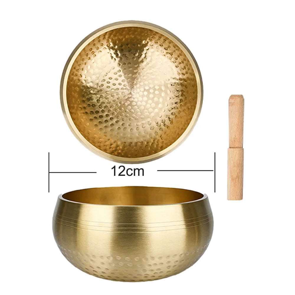 A brass Tibetan singing bowl with a wooden mallet and a lid shown in various views.