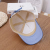 A light blue baseball cap with a beige lining and adjustable strap resting on a wooden surface.