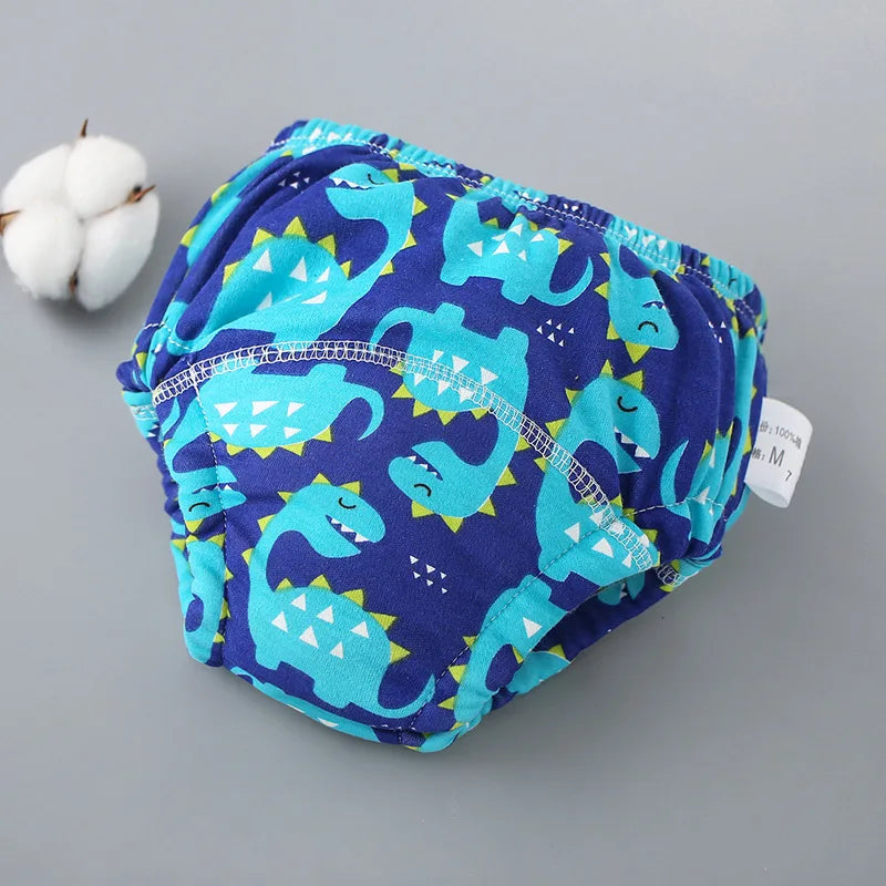 Un paquete de pantalones de entrenamiento lavables con estampado azul y verde azulado para bebés, con una bola de algodón bla