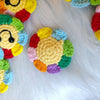 Handmade crochet sunflower decorative smile orb with colorful petals resting on white fur