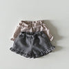 A set of baby girl ruffle top and shorts in checkered patterns, featuring beige and black fabrics.