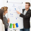 A man points to a whiteboard diagram showing business planning concepts and colored erasers.