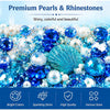 A collection of shiny, colorful pearls and rhinestones in blue and white shades.