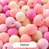 A close-up view of numerous pastel pink and peach bear-shaped acrylic craft beads.