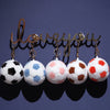 A row of realistic football plush pillows in various colors and patterns, suspended by gold-toned chains.
