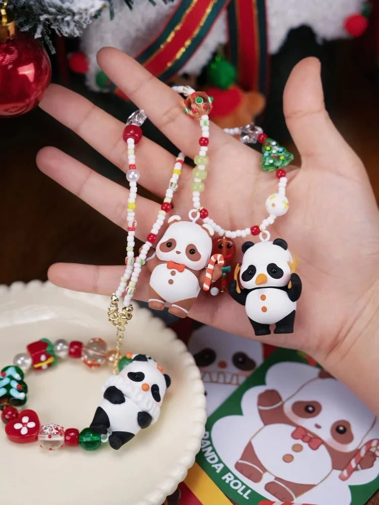 A hand holds a panda blind box collectible figure and beaded jewelry against a festive Christmas background.