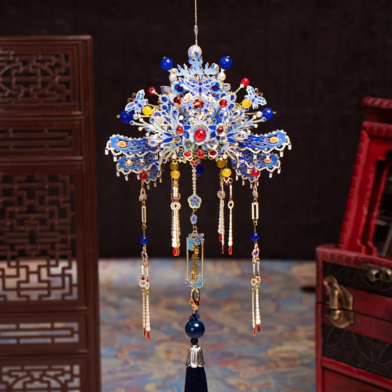 A detailed blue and gold metal phoenix crown model kit decoration hanging from a thread.