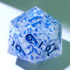 A translucent blue resin D20 die with a large, faceted shape decorated with blue and purple floral liquid swirls.