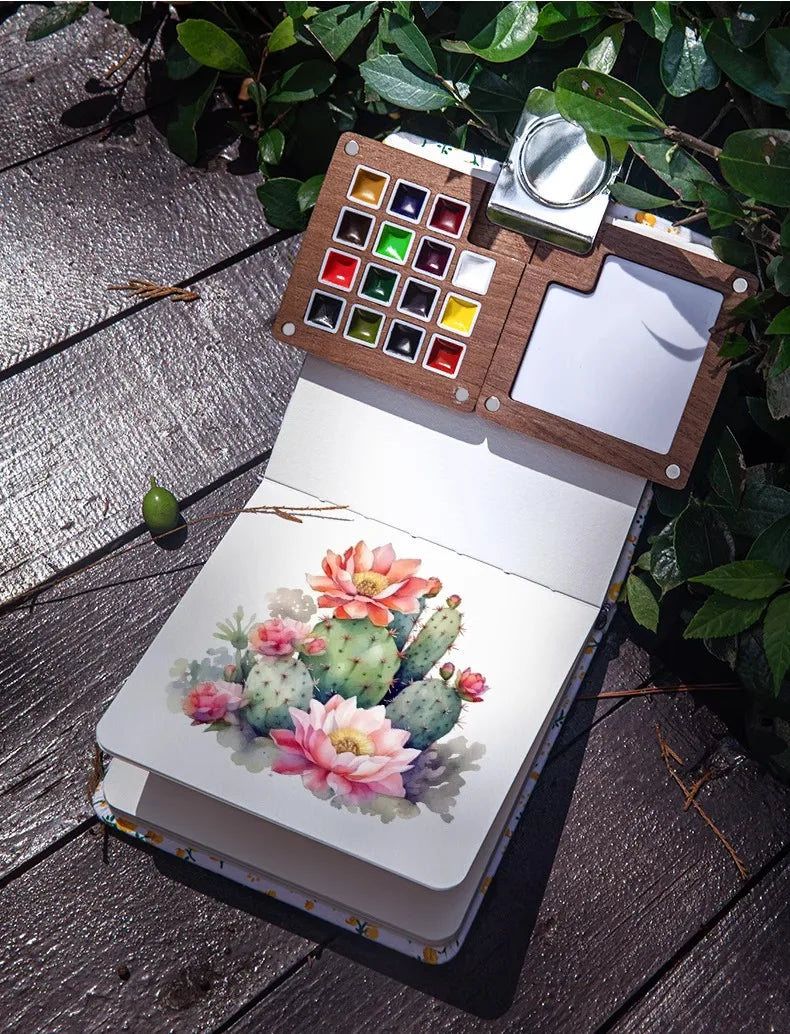 A portable wooden watercolor paint set with a palette and a watercolor painting of a pink cactus on a white background.