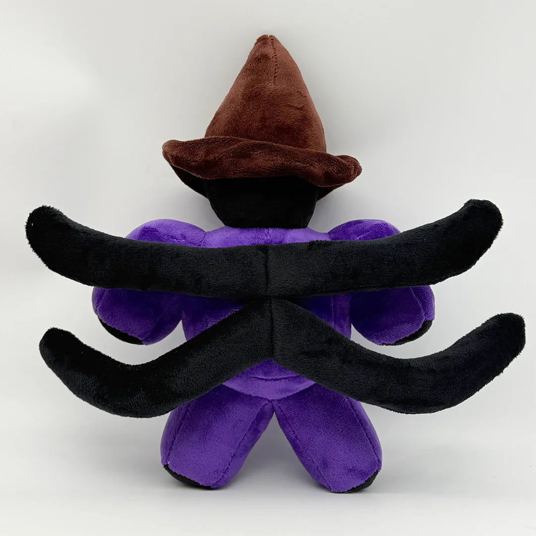 A plush toy featuring a brown witch hat and black, curved ears on a purple body.