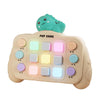 A beige Montessori busy board with light-up switches and a green character topper for toddlers.