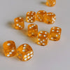 A collection of bright orange transparent dice scattered on a white surface.