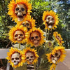 A display of skull sunflower garden decorations on green foliage.