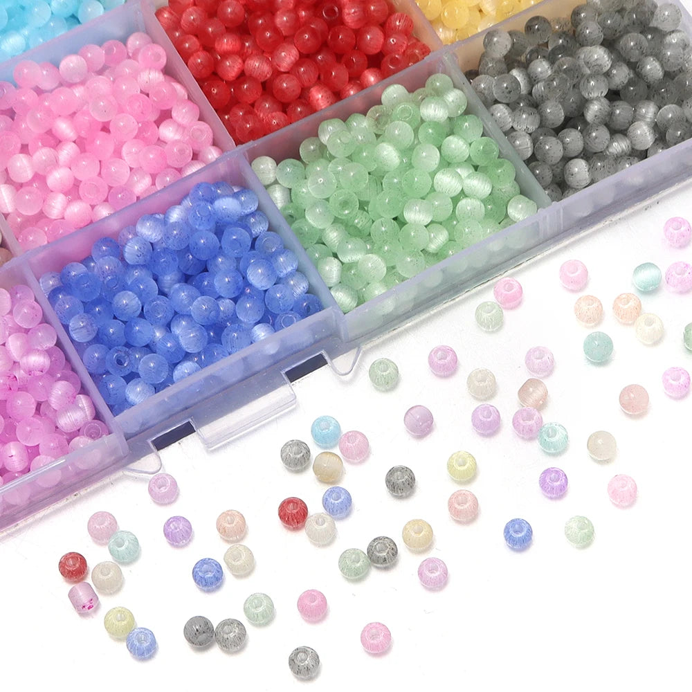 A collection of colorful glass beads in various shades including pink, red, green, and blue, displayed in a clear plastic con