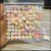A clear plastic bag filled with numerous colorful squishy toys shaped like cat paws for stress relief and fidgeting.