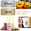 A set of permanent fine-tip markers in silver and gold colors, alongside orange peel fruit.