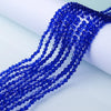 A close-up of a strand of deep blue faceted crystal beads used for jewelry making.