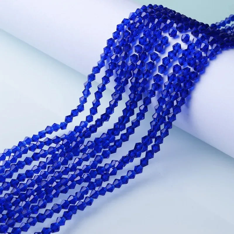 A close-up of a strand of deep blue faceted crystal beads used for jewelry making.