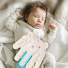 Un bébé dort en utilisant un massage de main rose pour apaiser sa paume.