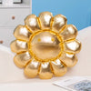 A large, golden sunflower plush cushion designed as a soft floor pillow with a cheerful face.